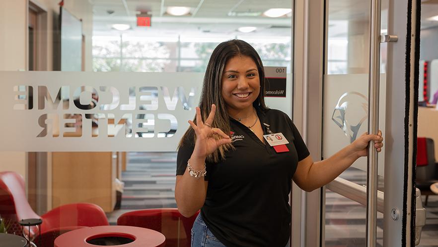 Orientation Leader standing by the Welcome Center door